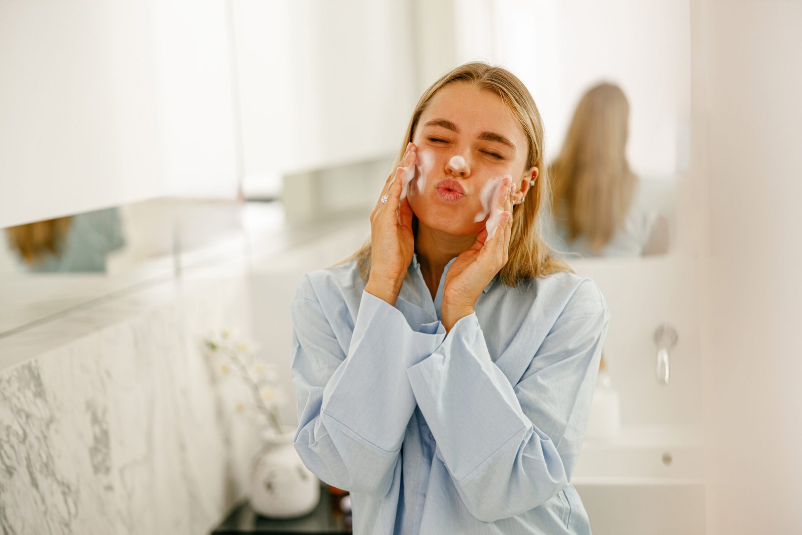 Skincare Routine A Young Woman Washing and Cleansing Her Face in a Bright and Cheerful Bathroom